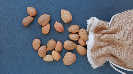 Sac en toile de jute et amandes sur ardoise  