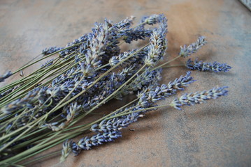 A bunch of dried lavender flowers on a wooden background.