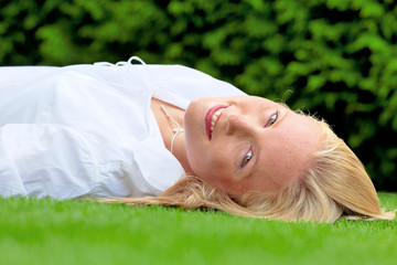 Frau liegt zur Erholung in der Wiese