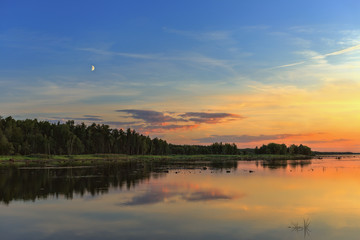 Fototapeta na wymiar .Beautiful sunset over the forest and lake.