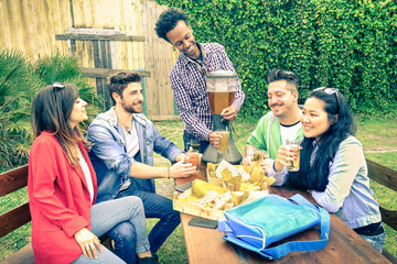 Multiracial group of happy friends eating and toasting at garden barbecue party - Concept of happiness with young people outdoors enjoying picnic food together - Vintage filtered look