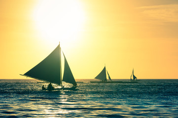 Fototapeta na wymiar Silhouette of typical sailing boats at sunset in Boracay island in Philippines