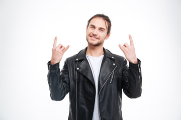 Smiling handsome man in black leather jacket doing rock gesture