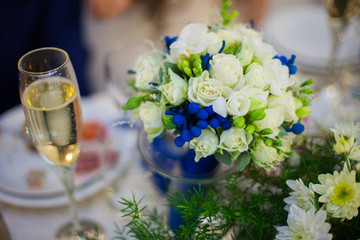 gorgeous decorated wedding table with bouquet and a glass of cha