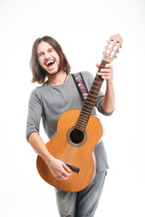 Fototapeta premium Excited handsome young man with long hair playing acoustic guitar