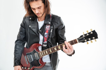 Obraz premium Handsome young man black leather jacket playing electric guitar