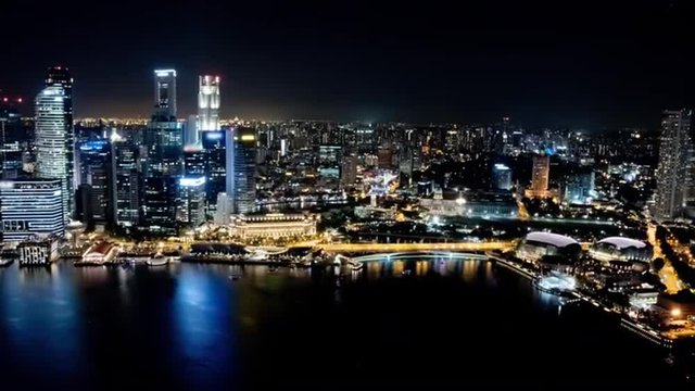 Time lapse of the Singapore skyline, western part, at night. Brands and trademarks have been blurred.
