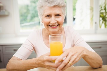 Happy senior woman having a glass of juice