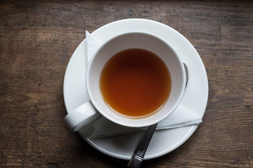 Obraz na płótnie Canvas Tea cup and tea from upside on wood table