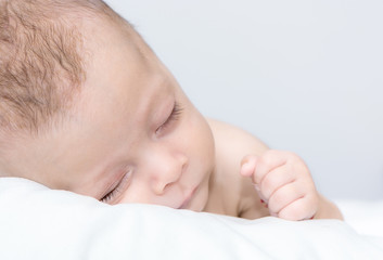 picture of a newborn baby curled up sleeping on a blanket