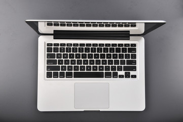 Fototapeta na wymiar Silver laptop with black button on grey background