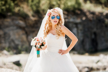 Fototapeta na wymiar young bride in blue glasses posing for a photograph on the background of nature.