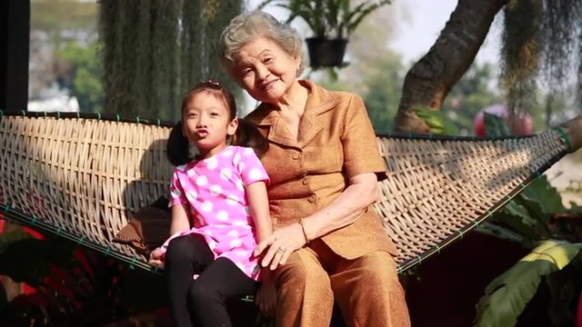 Grand mother enjoy playing with child on swing