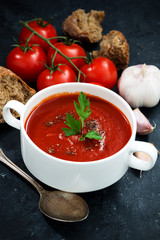 tomato cream soup on a dark background, vertical