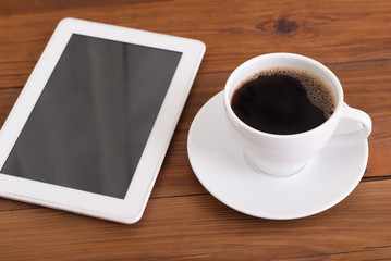 Fototapeta na wymiar Digital tablet and cup of coffee on wooden desk.