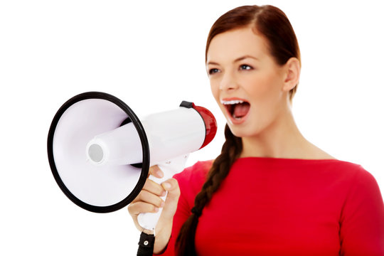 Young angry woman screaming through a megaphone