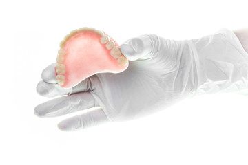 denture and handglove on white background