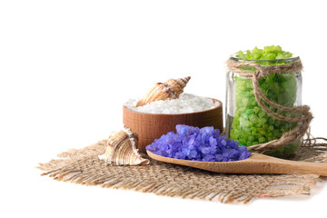 Fototapeta na wymiar purple and green is sea salt in wooden spoon and wooden bowl and in a glass jar on the fabric on a white isolated background