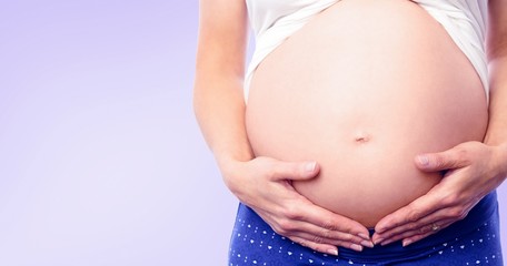 Composite image of pregnant woman holding her bump