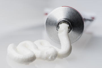 Close up of aluminum tube and white cream, isolated background. Cosmetic or medicine gel