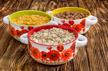 bowls with dry breakfast on a wooden table