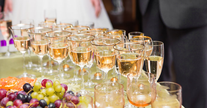 a row of glasses filled with champagne are lined up ready to be served