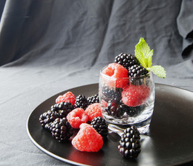 black berries and raspberries in a glass cup