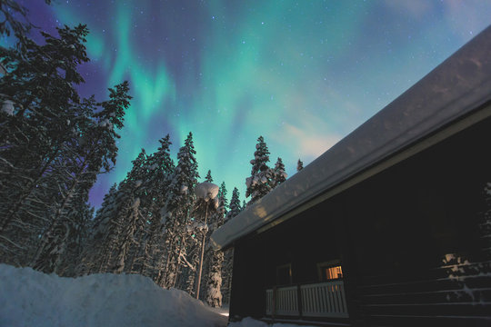 Beautiful picture of massive multicoloured vibrant Aurora Borealis, Aurora Polaris, also know as Northern Lights in the night sky over winter Lapland landscape 

