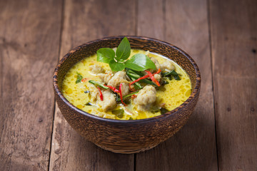 Green curry fish balls on wood background.