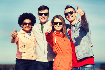 happy teenage friends in shades hugging outdoors