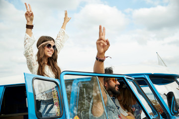hippie friends over minivan car showing peace sign