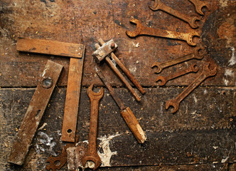 Old rusty wrench on dirty wooden table