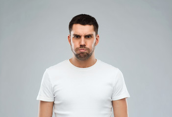 man with funny angry face over gray background