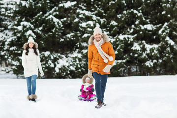Fototapeta na wymiar happy family with sled walking in winter forest