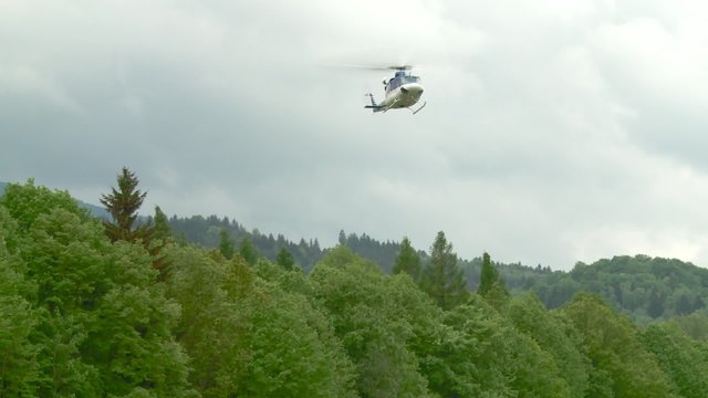 Helicopter flies and lands in the landscape. 