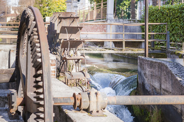 Old iron wheel a watermill. Ruins of a watermill. © Franco Nadalin