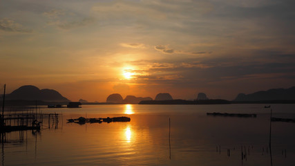 Obraz premium Landscape of nature sunrise/ sunset in the sea at Samchong fishing village in Phang-Nga, Thailand
