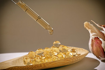 Glass dropper on capsules of garlic oil