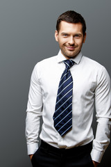 Handsome stylish businessman on grey background