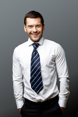 Handsome stylish businessman on grey background