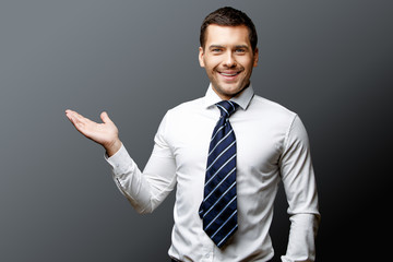 Handsome stylish businessman on grey background