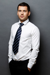 Handsome stylish businessman on grey background