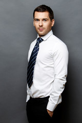 Handsome stylish businessman on grey background