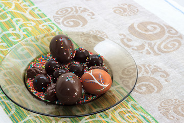 Chocolates, hand-made egg, chocolate eggs and raisins on easter breakfast table