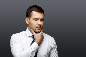 Obraz premium Handsome stylish businessman on grey background