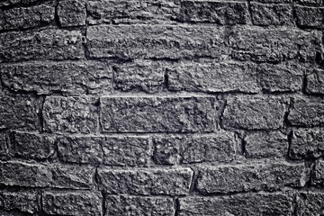 Stone wall with brick. Black-and-white image into a depression, the anger. Changes of contrast. Vignetting. Apply light and color effects to create the dramatic atmosphere of the picture.
