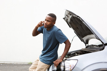 African man calling on cellphone for car service