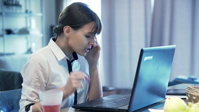 Angry businesswoman talking on cellphone in the office
