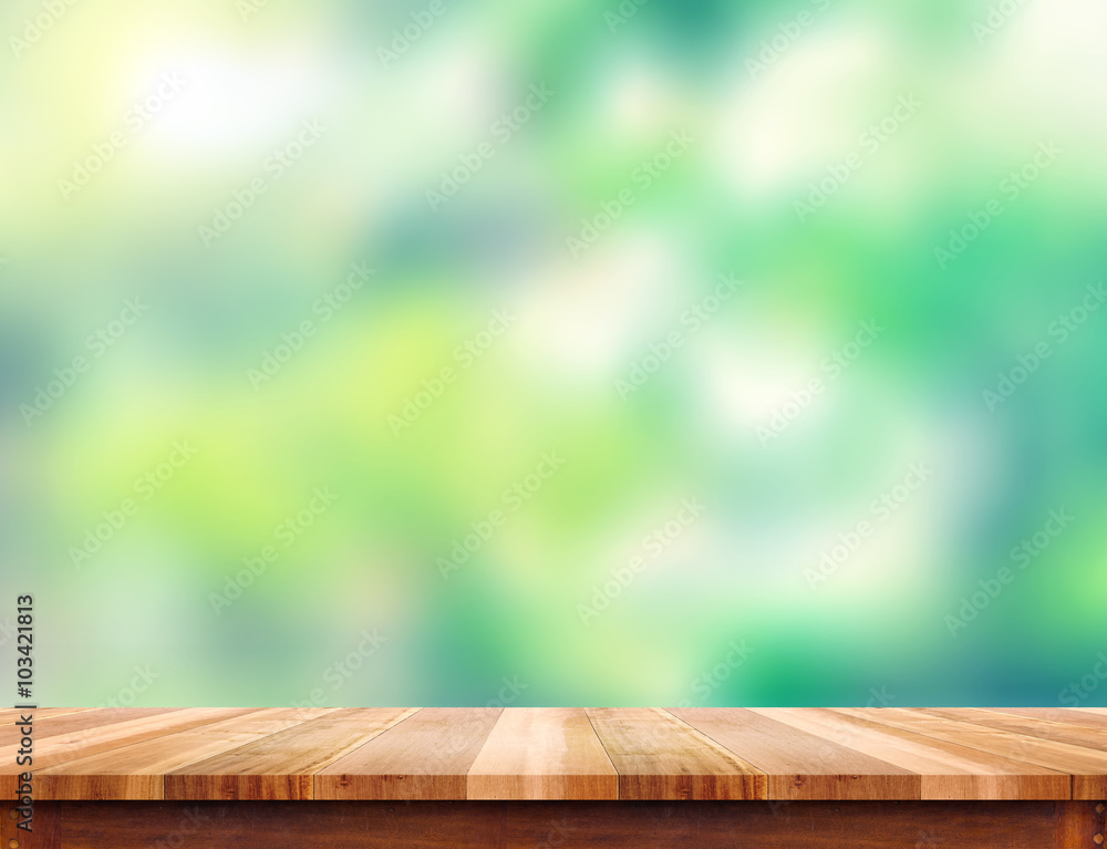 Poster empty plank brown wood table top with blur green tree background