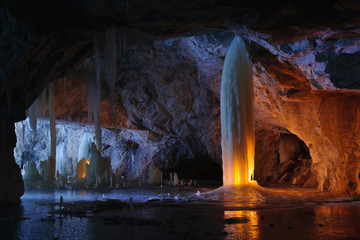 Ice column illuminated by candles inside the marble mine. Ruskeala, Karelia, Russia. - 103421883